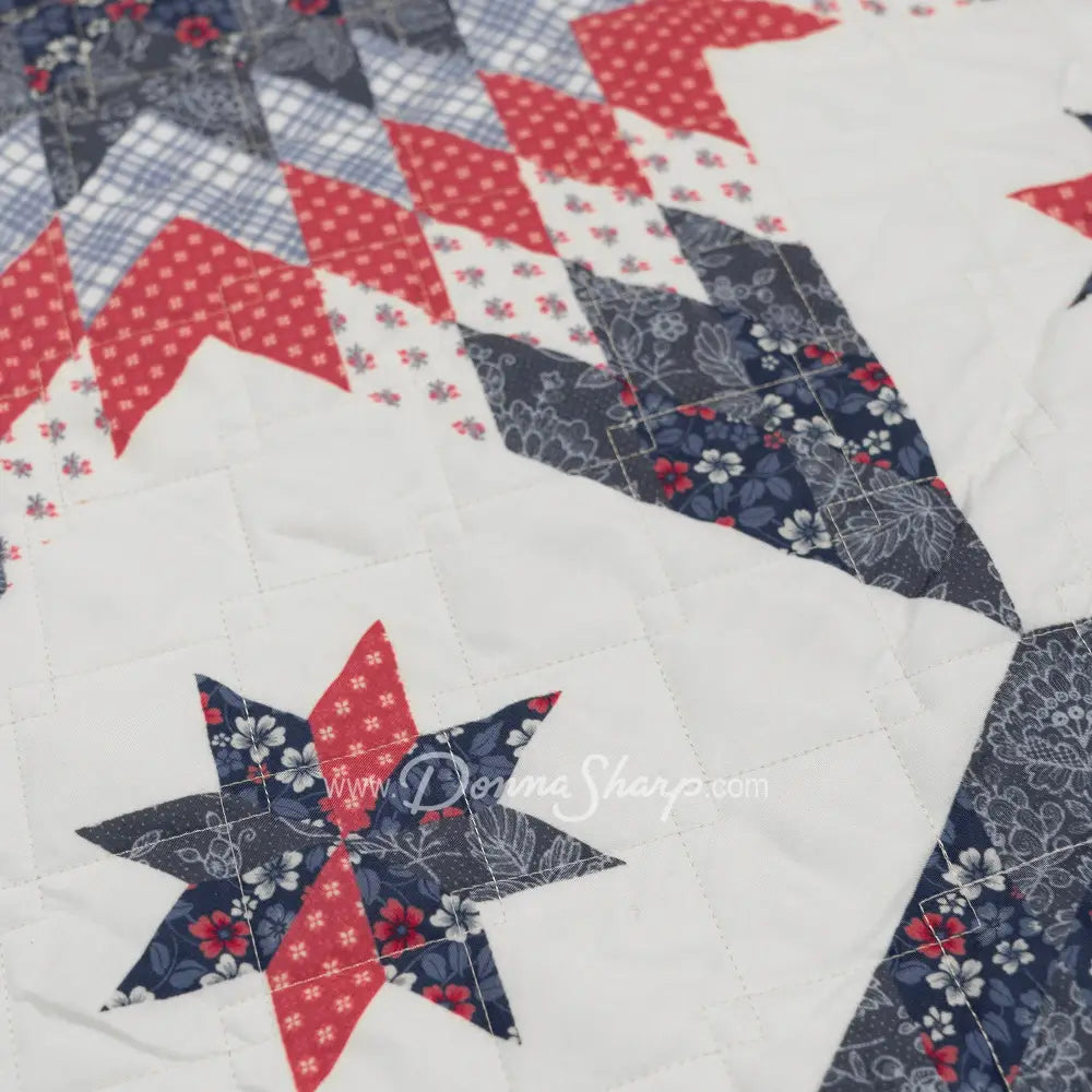 Donna Sharp Bluefield Star quilt detail featuring eight-point star blocks in navy, country blue, periwinkle, rose, and raspberry with a pale ivory background and diamond quilting