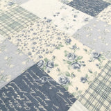 Close-up of Donna Sharp Blue Pastures cotton quilt showing patchwork blocks with soft blues, gentle creams, and crisp whites rose patterns with diamond quilting