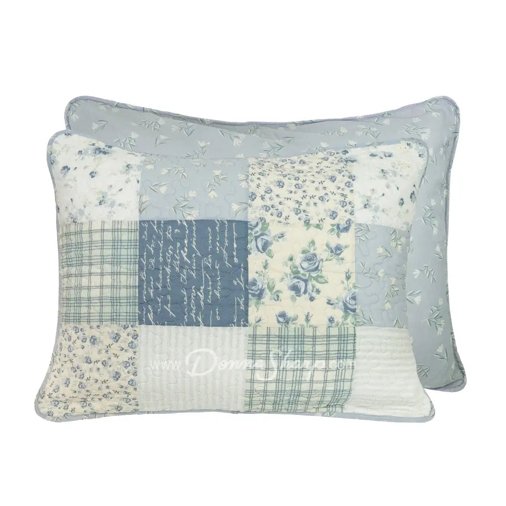 Donna Sharp Blue Pastures reversible cotton pillow shams showing patchwork front in blue, gray and cream with floral, plaid and script patterns, and blue floral back