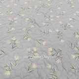 Close-up of Donna Sharp Blue Pastures cotton quilt reverse fabric showing soft gray background with delicate cream floral sprigs 