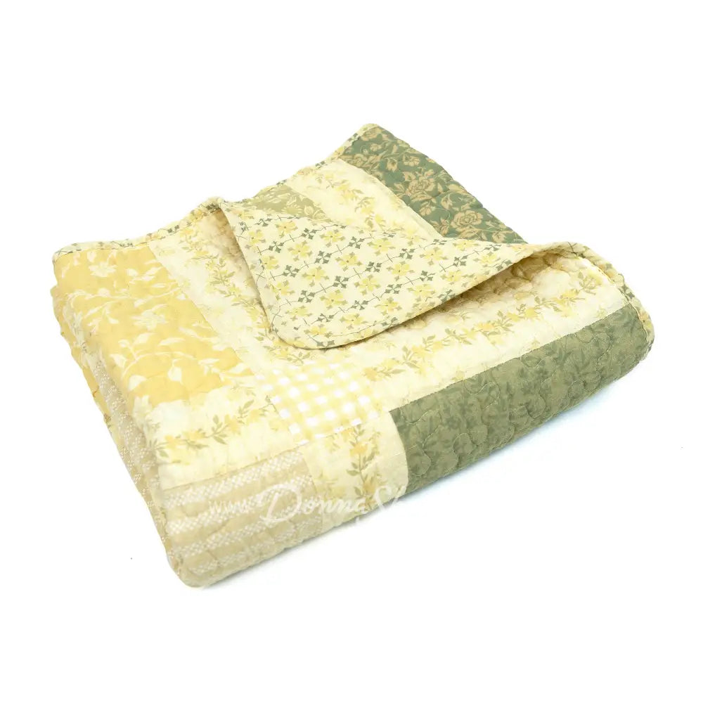 Donna Sharp Meadow reversible cotton throw blanket folded to show sage green and cream floral patchwork patterns on both sides